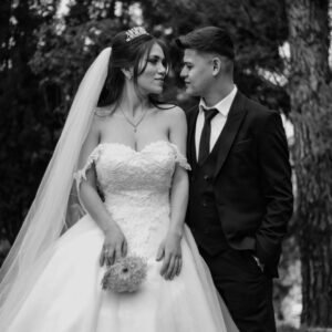 Home Elegant black and white portrait of a bride and groom captured outdoors, showcasing wedding fashion.