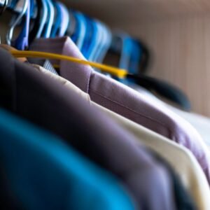 Home Close-up of various shirts hanging on colorful hangers inside a wardrobe.